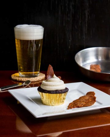 Vegan bacon cupcake on plate with beer in background