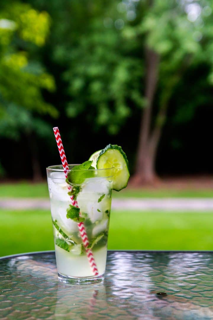 Cocktail with mint leaves and cucumbers on outdoor table