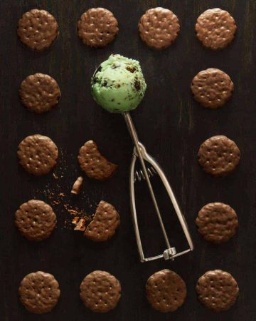 Grid of Thin Mints on black background with green ice cream in ice cream scoop in center