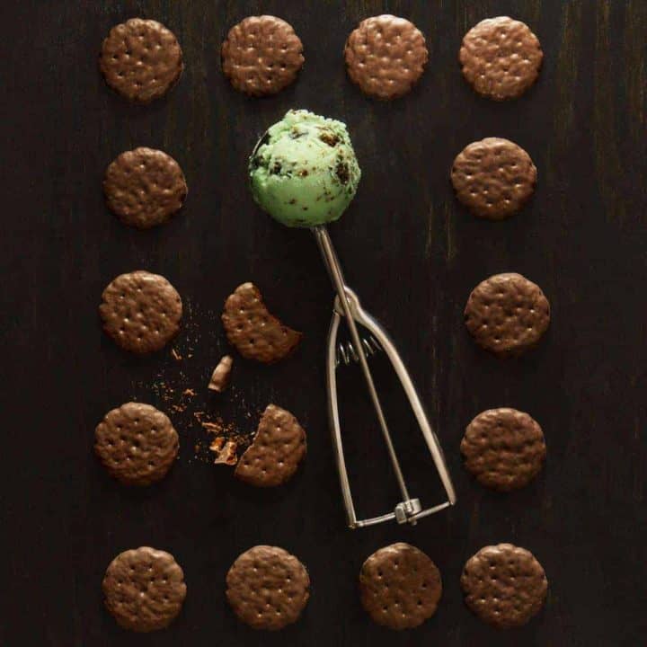 Grid of Thin Mints on black background with green ice cream in ice cream scoop in center