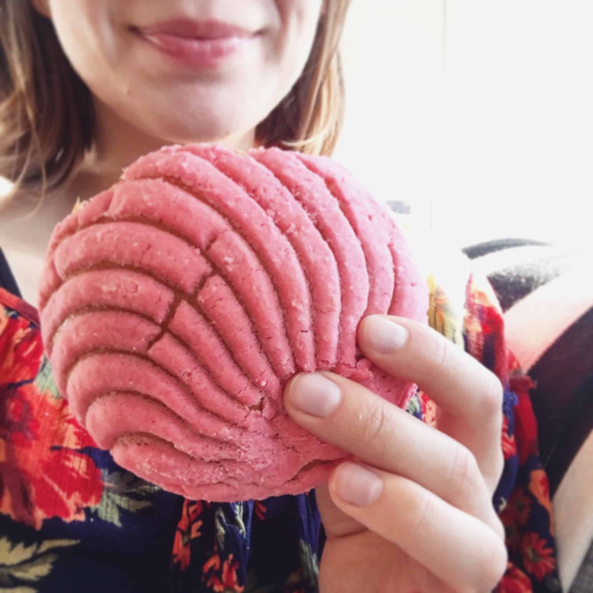Person holding a pink vegan concha