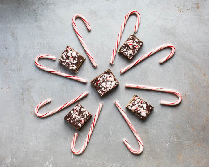 Chocolate peppermint cream bars in center surrounded by candy canes in snowflake shape