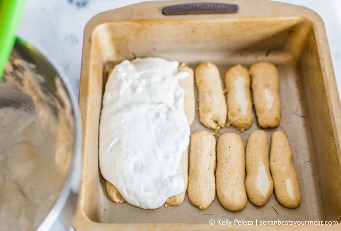 Espresso-soaked ladyfinger cookies in pan with cashew mascarpone on top