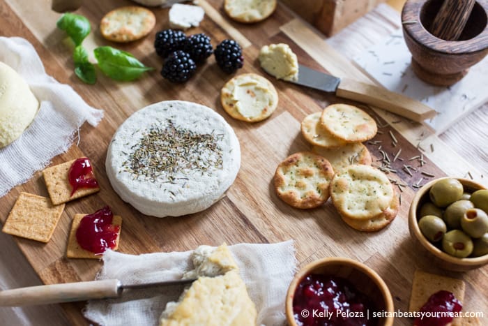 Vegan cheese board surrounded by wine and decor