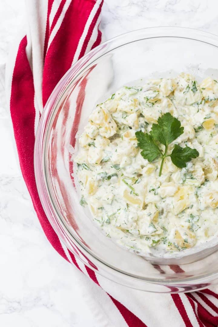 Large bowl of potato salad with red and white dish towel