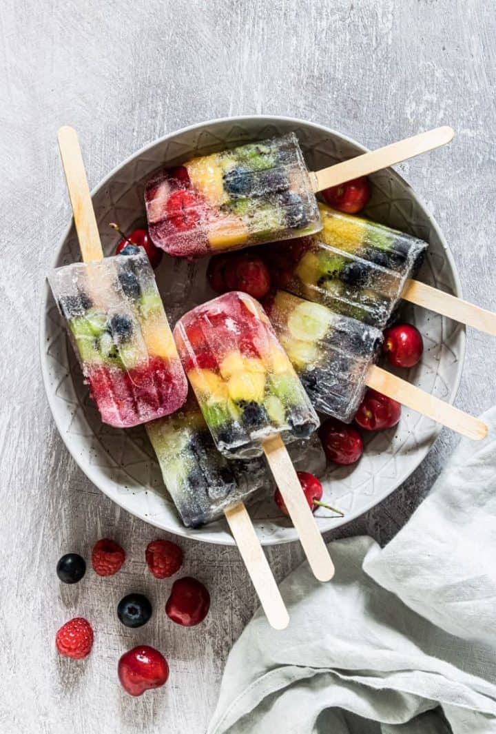 Colorful ice pops made of fruit arranged in rainbow order