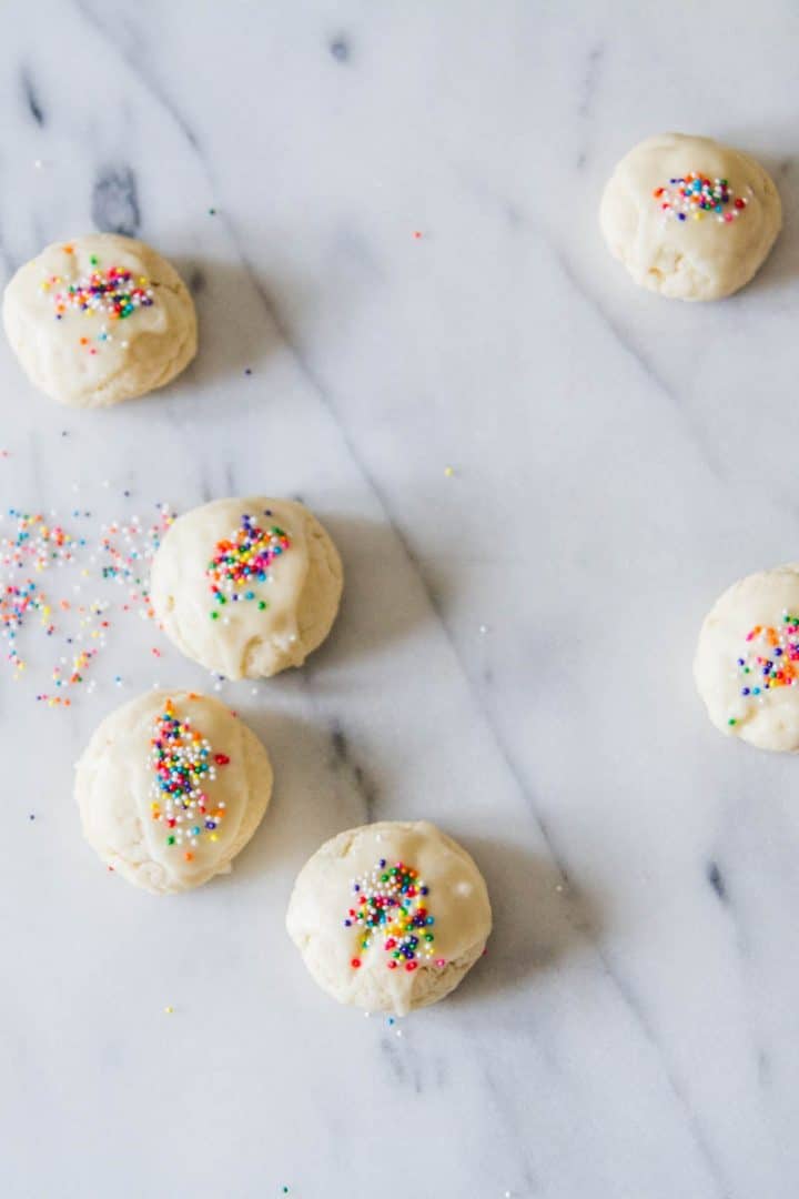 6 cookies with rainbow nonpareils on a marble counter
