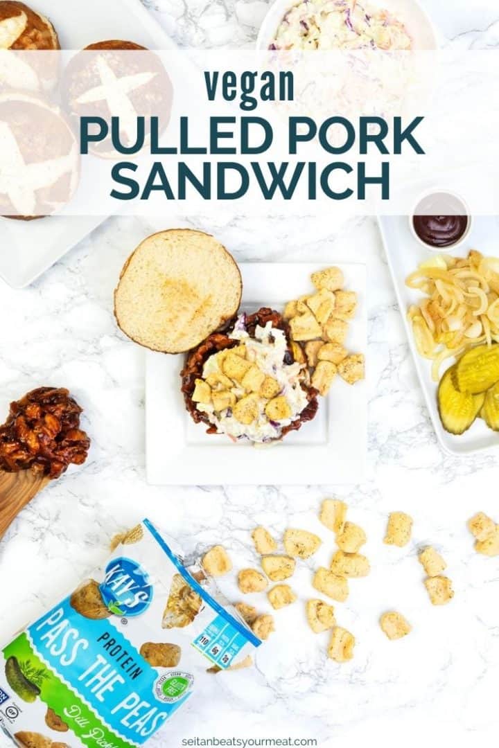 Overhead image of barbecue sandwich on plate with chips on top and buns, coleslaw, and toppings off to side with text "Vegan Pulled Pork Sandwich"