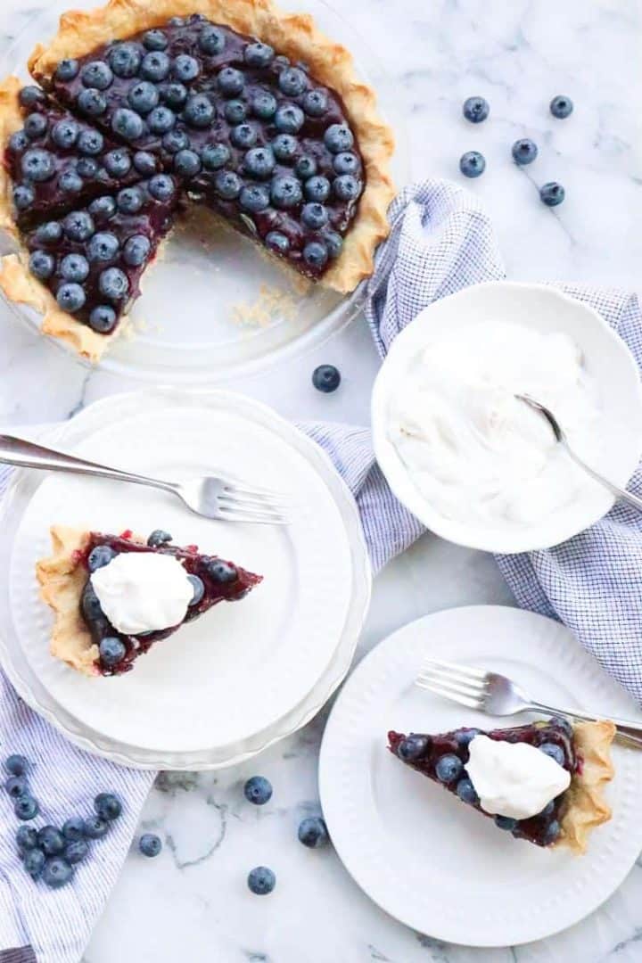 Slices of blueberry pie with whipped cream