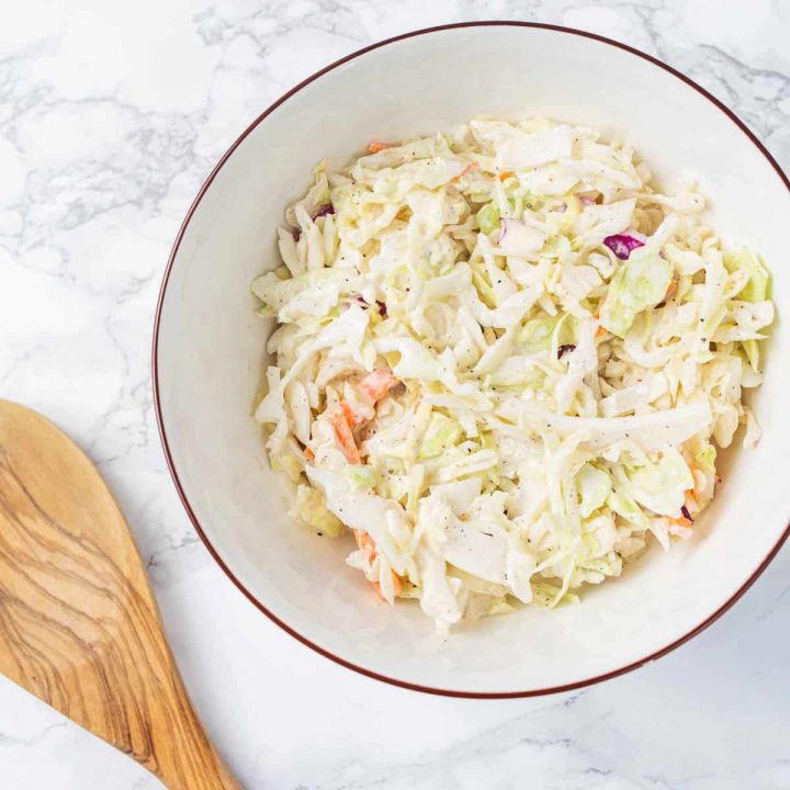 Bowl of vegan coleslaw on marble counter