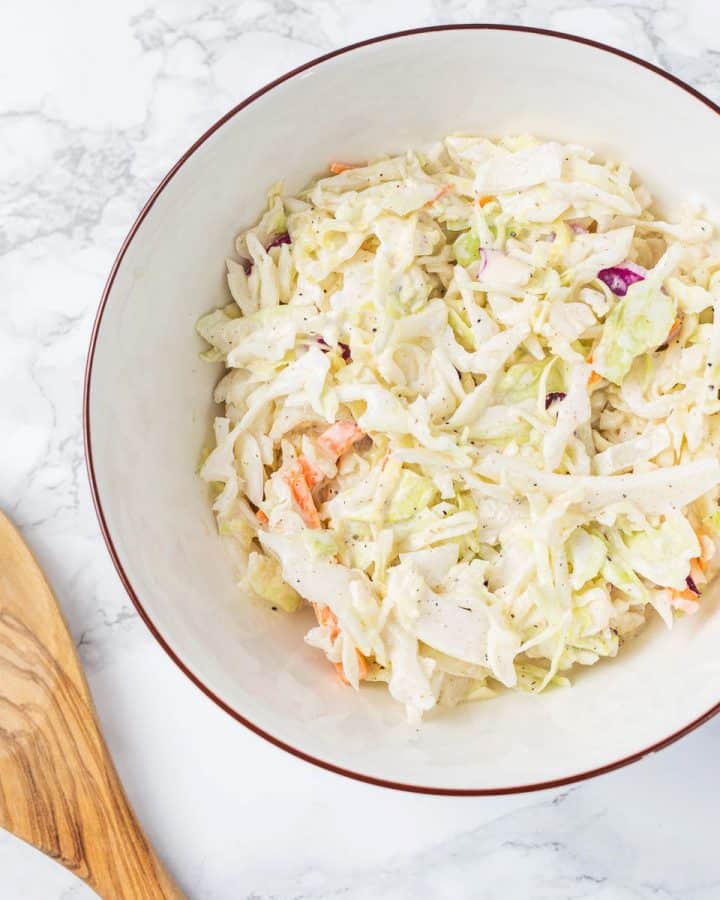 Bowl of vegan coleslaw on marble counter