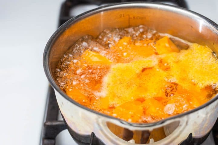 Boiling sweet potatoes in pot on stove